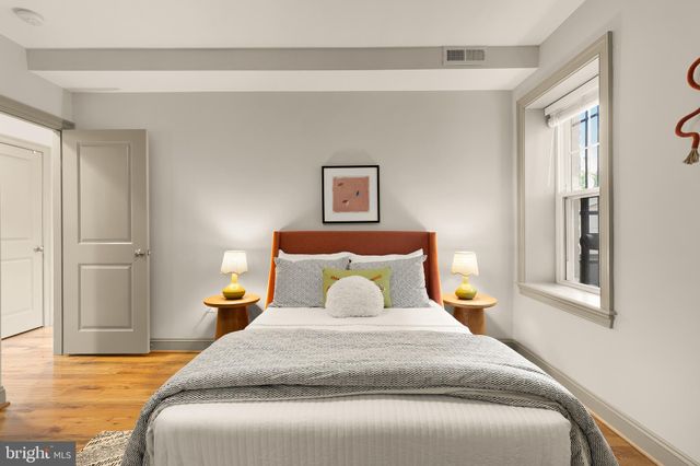 a bedroom with a bed and wooden floor