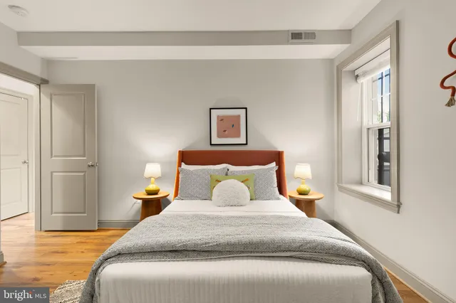 a bedroom with a bed and wooden floor