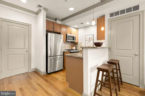 a kitchen with stainless steel appliances a refrigerator and a stove top oven