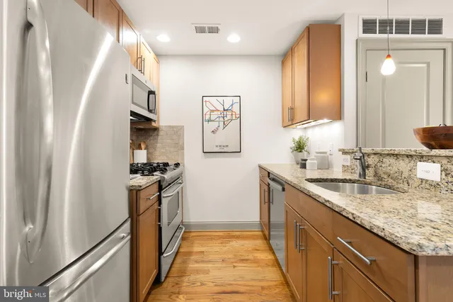 a kitchen with granite countertop a sink and a refrigerator
