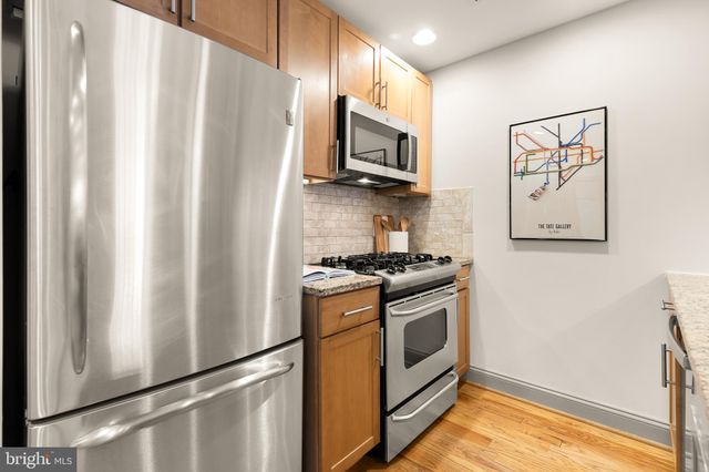 a kitchen with stainless steel appliances a refrigerator sink and microwave