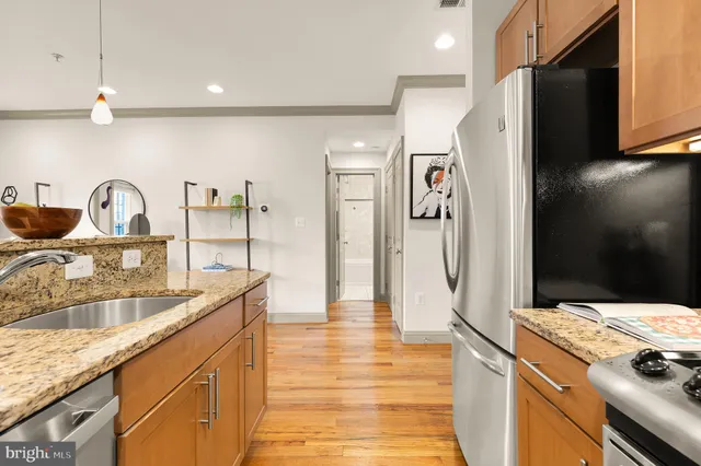 a kitchen with stainless steel appliances granite countertop a sink and a refrigerator