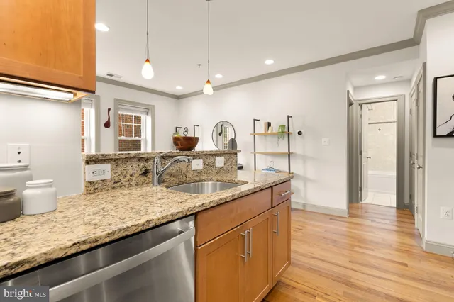 a kitchen with granite countertop a sink cabinets and wooden floor