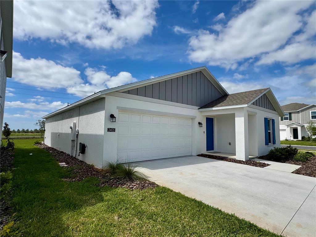 2405 Bluestone Road Haines City, FL 33844 - Photo 2 of 18 a view of a white house with a big yard and large trees