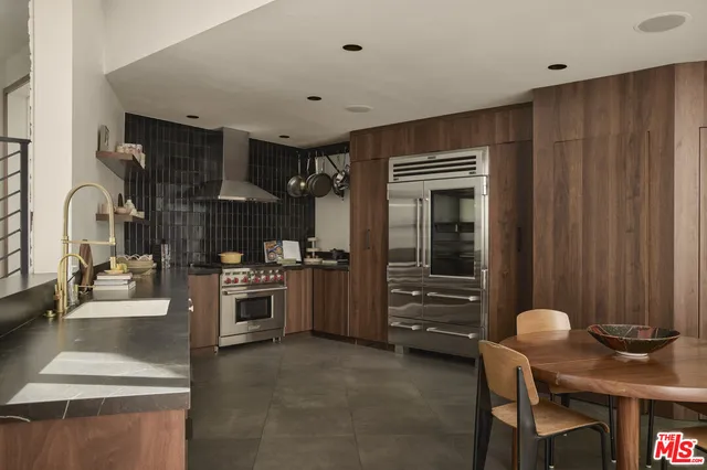 a roof deck with couches and potted plants