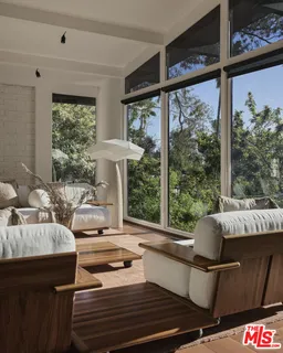 a living room with furniture and a floor to ceiling window