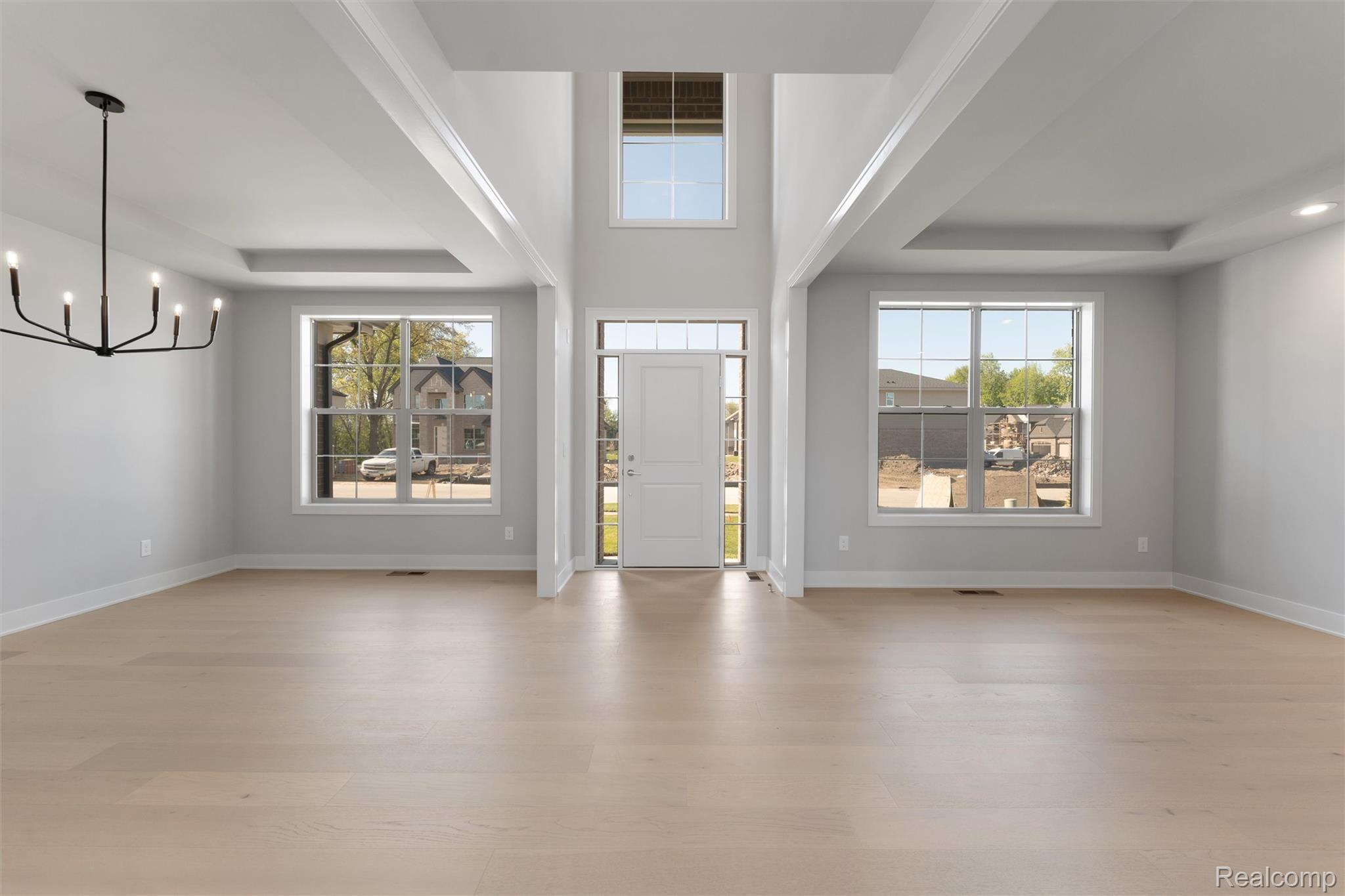 3989 Capstan Court Troy, MI 48083 - Photo 3 of 19 Entryway featuring a raised ceiling, suspended lighting, light wood-style flooring, and plenty of natural light