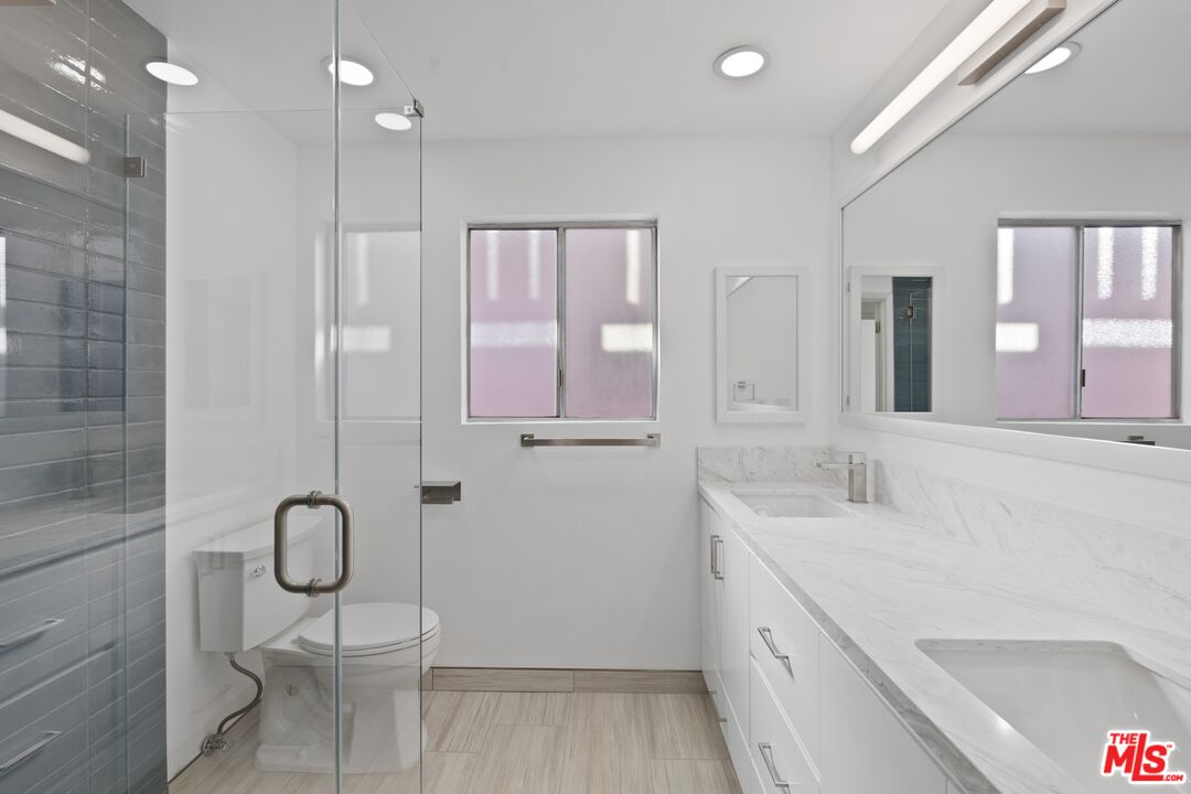122 Buccaneer Street, Unit 3 Marina del Rey, CA 90292 - Photo 20 of 31 a bathroom with a granite countertop sink a toilet and shower