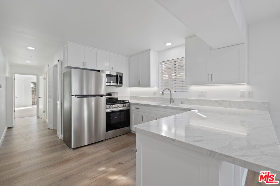 122 Buccaneer Street, Unit 3 Marina del Rey, CA 90292 - Photo 9 of 31 a kitchen with stainless steel appliances a refrigerator and a sink