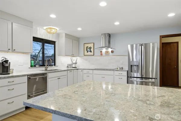 a kitchen with granite countertop a refrigerator stove top oven and sink