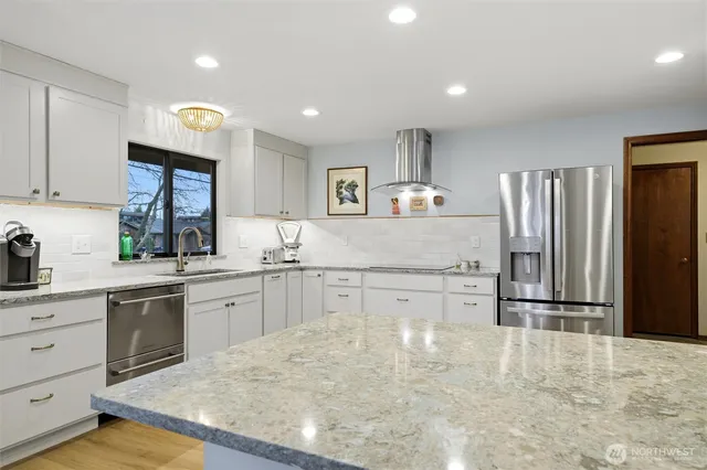 a kitchen with granite countertop a refrigerator stove top oven and sink