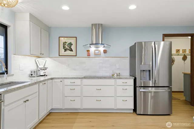 a kitchen with stainless steel appliances granite countertop a refrigerator and a sink