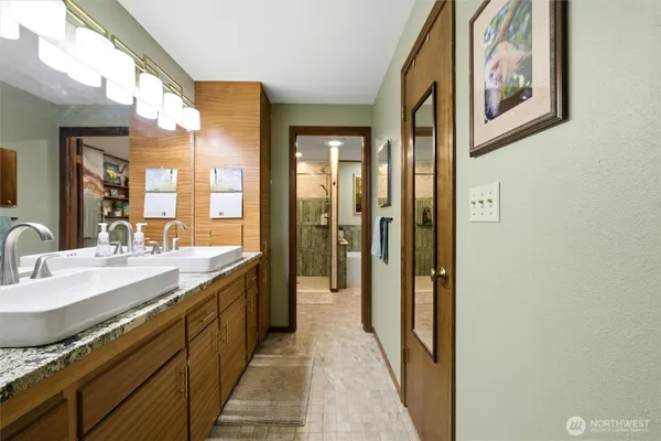 a spacious bathroom with a granite countertop sink and a mirror