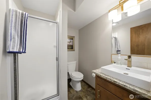 a bathroom with a granite countertop sink toilet and shower
