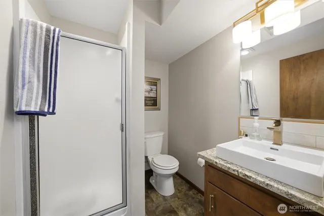 a bathroom with a granite countertop sink toilet and shower