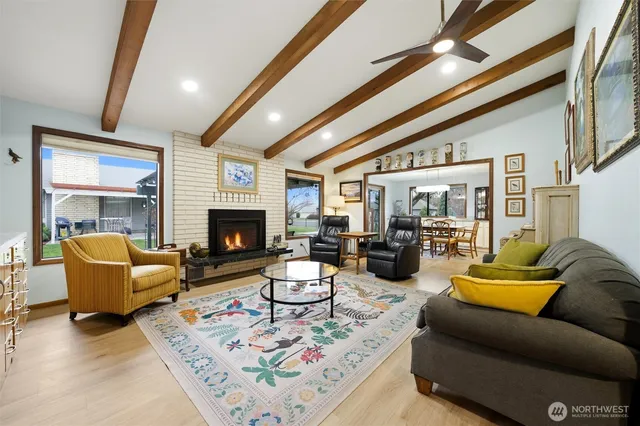 a living room with furniture fireplace and a large window