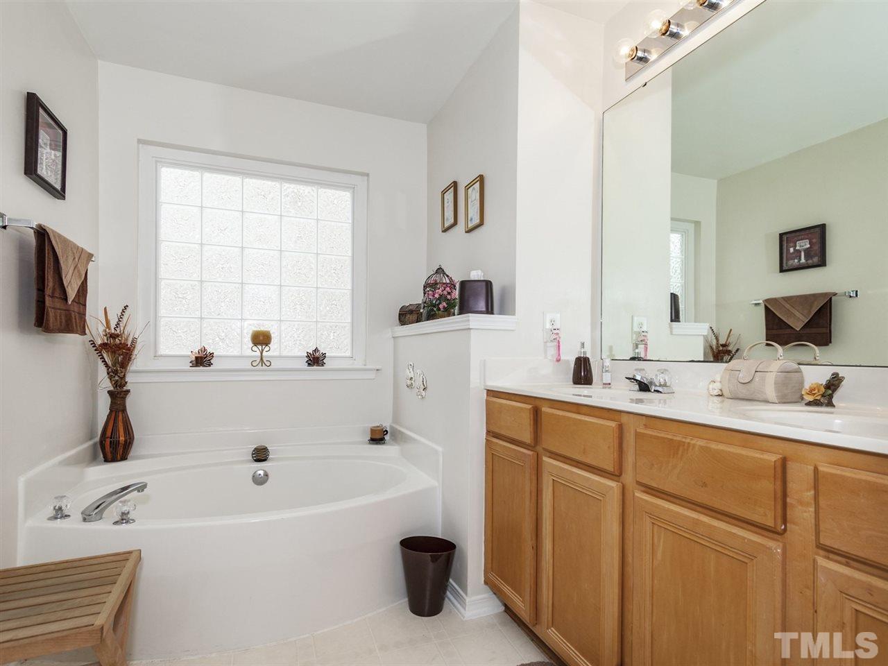8506 Slabstone Court Raleigh, NC 27613 - Photo 14 of 25 a bathroom with a tub sink and mirror