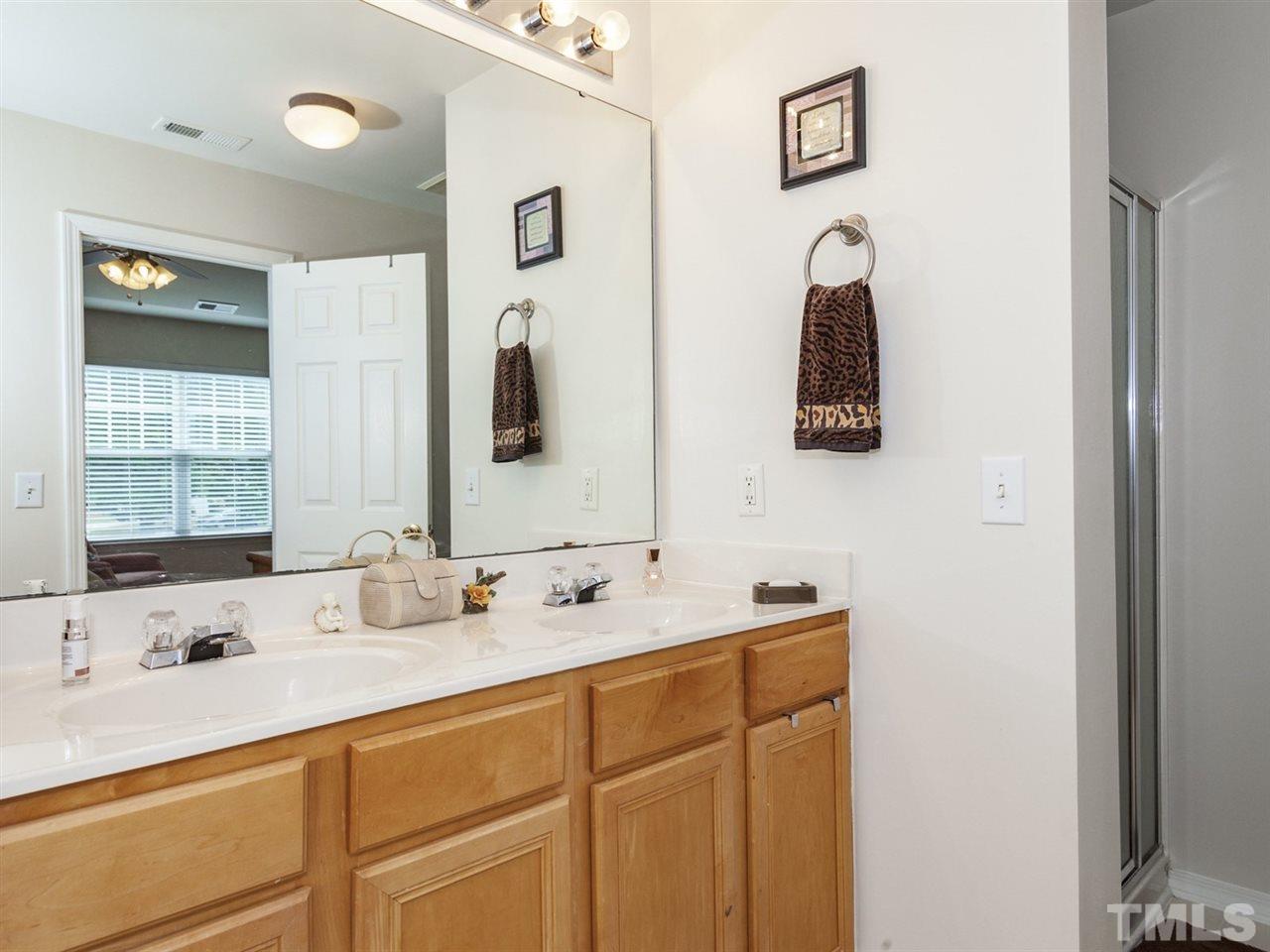 8506 Slabstone Court Raleigh, NC 27613 - Photo 15 of 25 a bathroom with a double vanity sink and a mirror