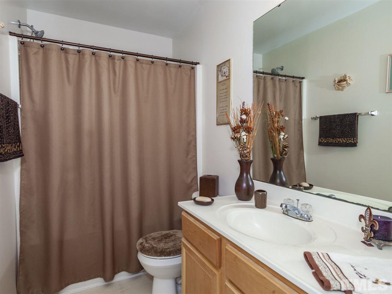 8506 Slabstone Court Raleigh, NC 27613 - Photo 19 of 25 a bathroom with a granite countertop sink and a mirror
