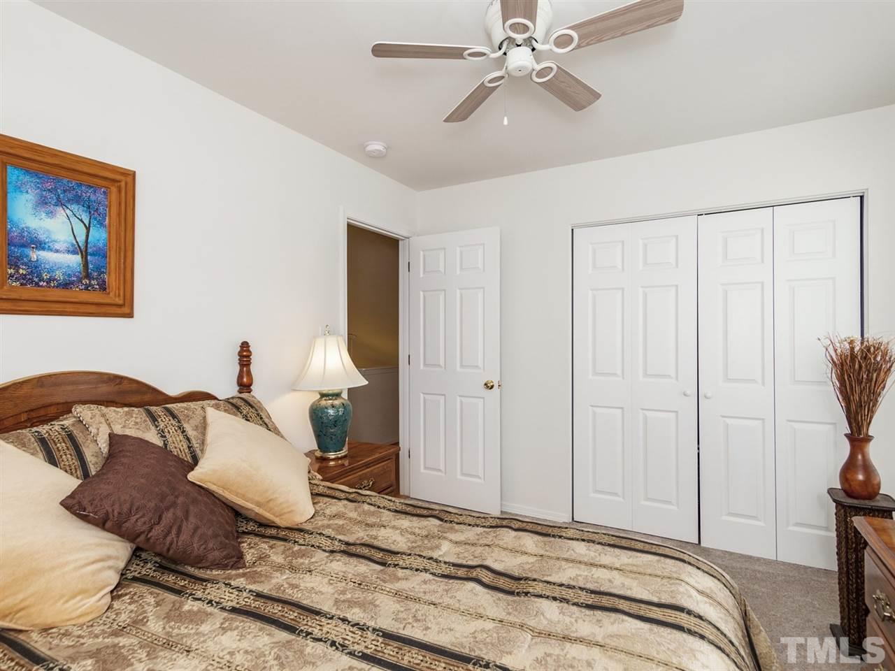 8506 Slabstone Court Raleigh, NC 27613 - Photo 21 of 25 a bedroom with a bed and a chandelier