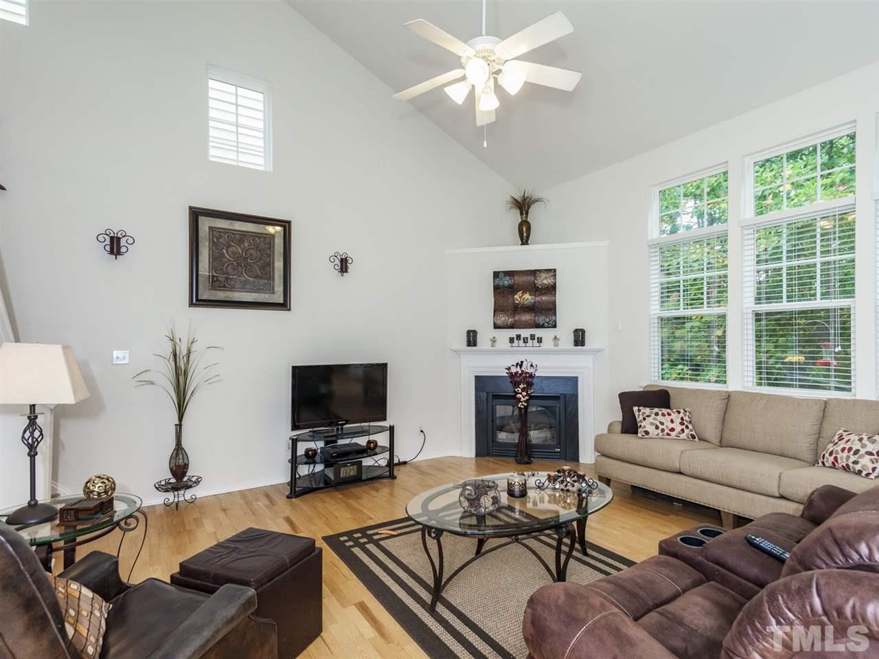 8506 Slabstone Court Raleigh, NC 27613 - Photo 7 of 25 a living room with furniture a large window and a flat screen tv