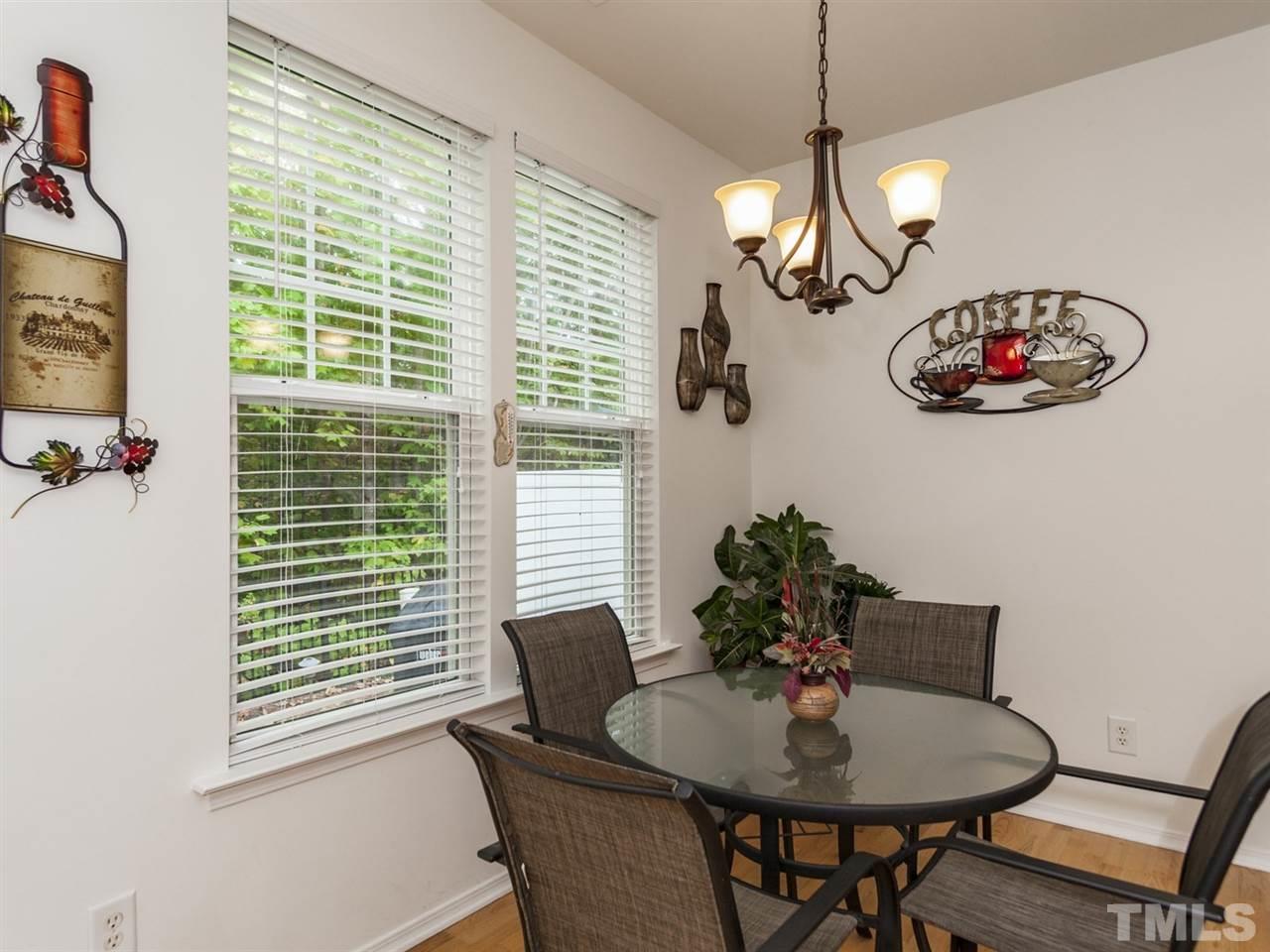8506 Slabstone Court Raleigh, NC 27613 - Photo 8 of 25 a view of a dining room with furniture wooden floor and a chandelier