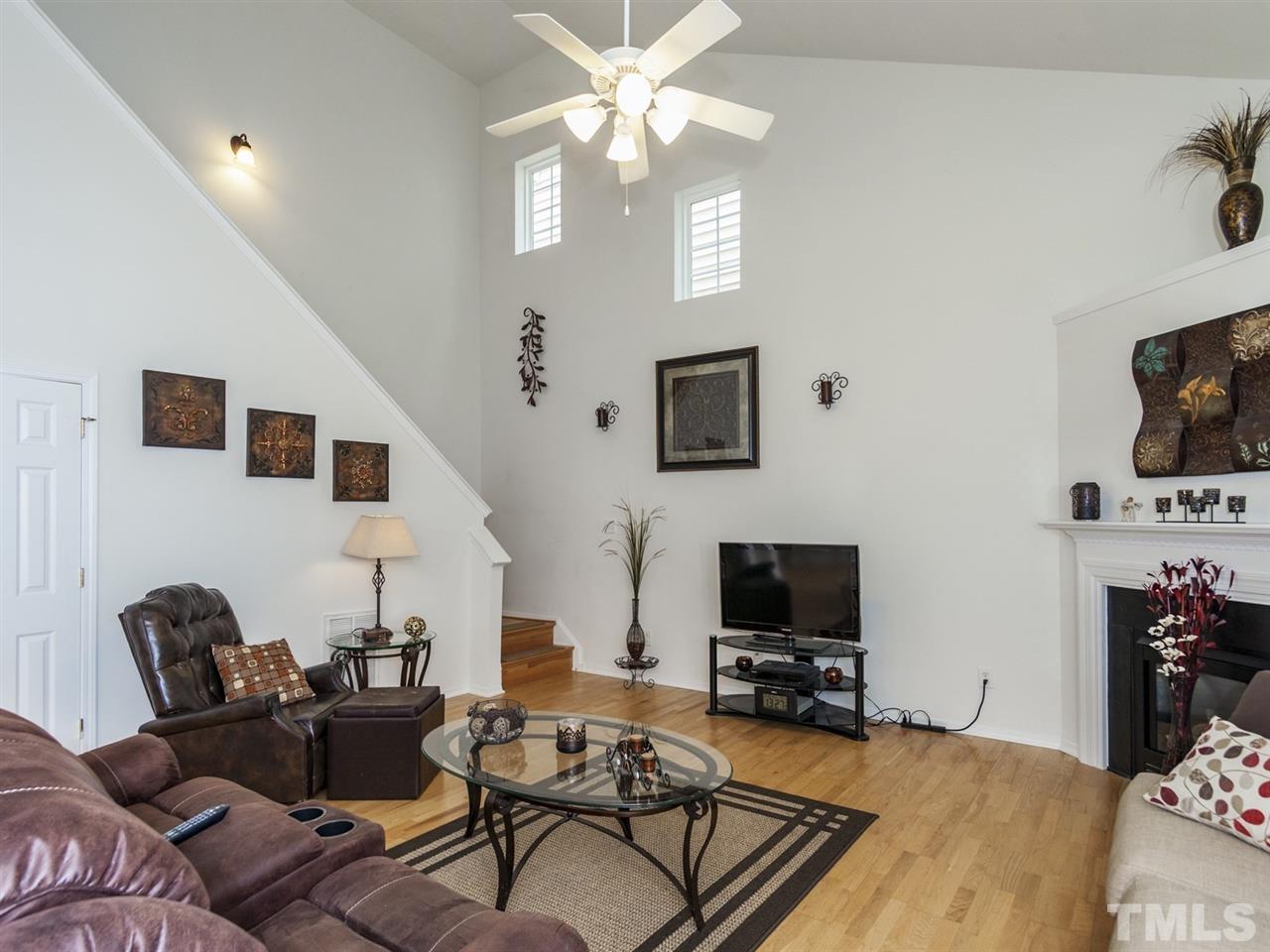 8506 Slabstone Court Raleigh, NC 27613 - Photo 10 of 25 a living room with furniture a flat screen tv and a fireplace