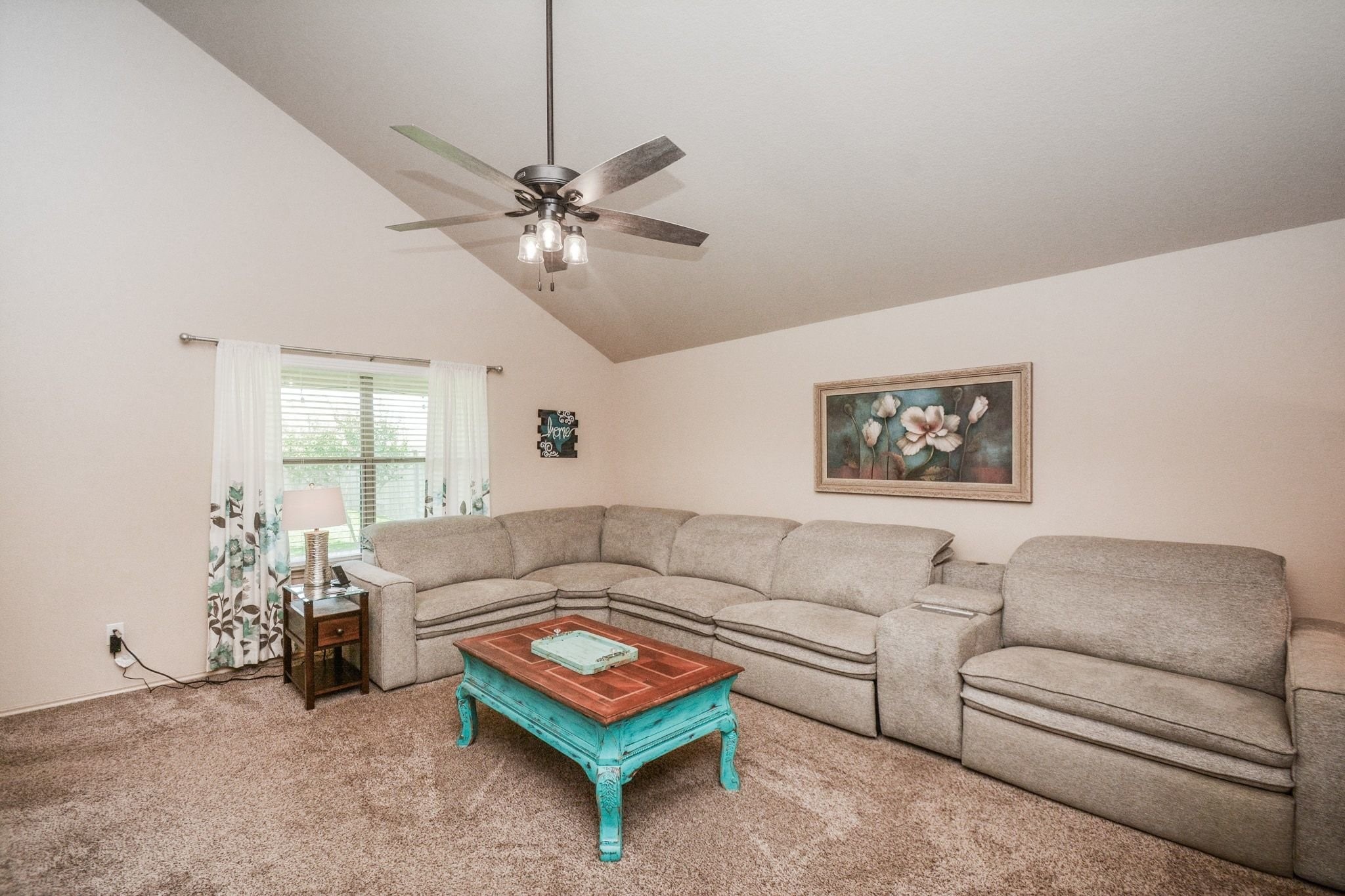 23318 Dukes Run Drive Spring, TX 77373 - Photo 16 of 41 This cozy living room features a vaulted ceiling, large sectional sofa, ceiling fan, and natural light from a window, overlooking the lush backyard.
