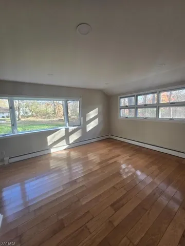 a view of empty room with wooden floor