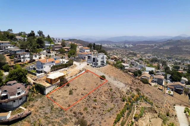 a view of a dry yard with wooden fence