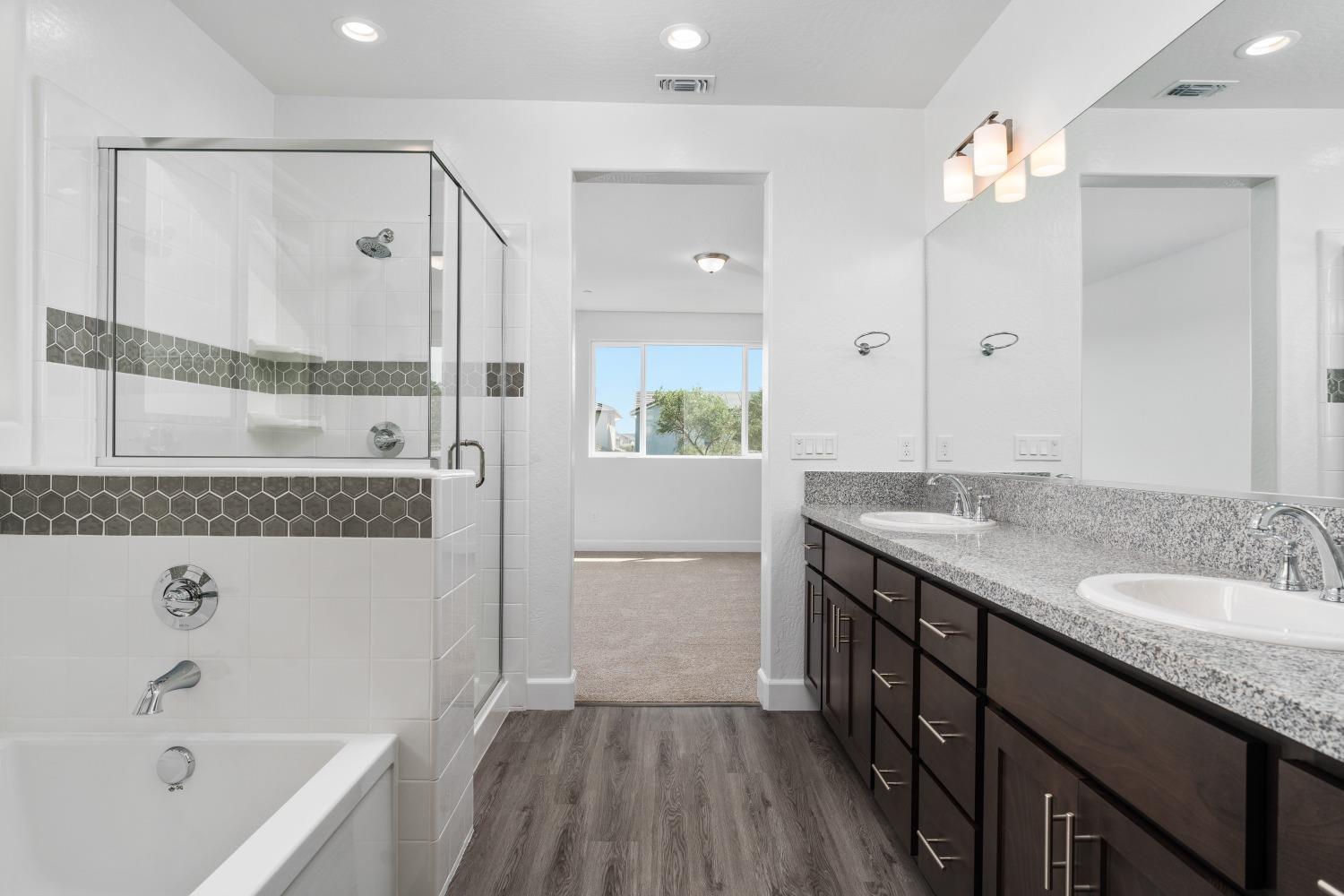 321 Peters Road Madera, CA 93636 - Photo 11 of 33 a bathroom with a granite countertop bathtub a sink and a mirror