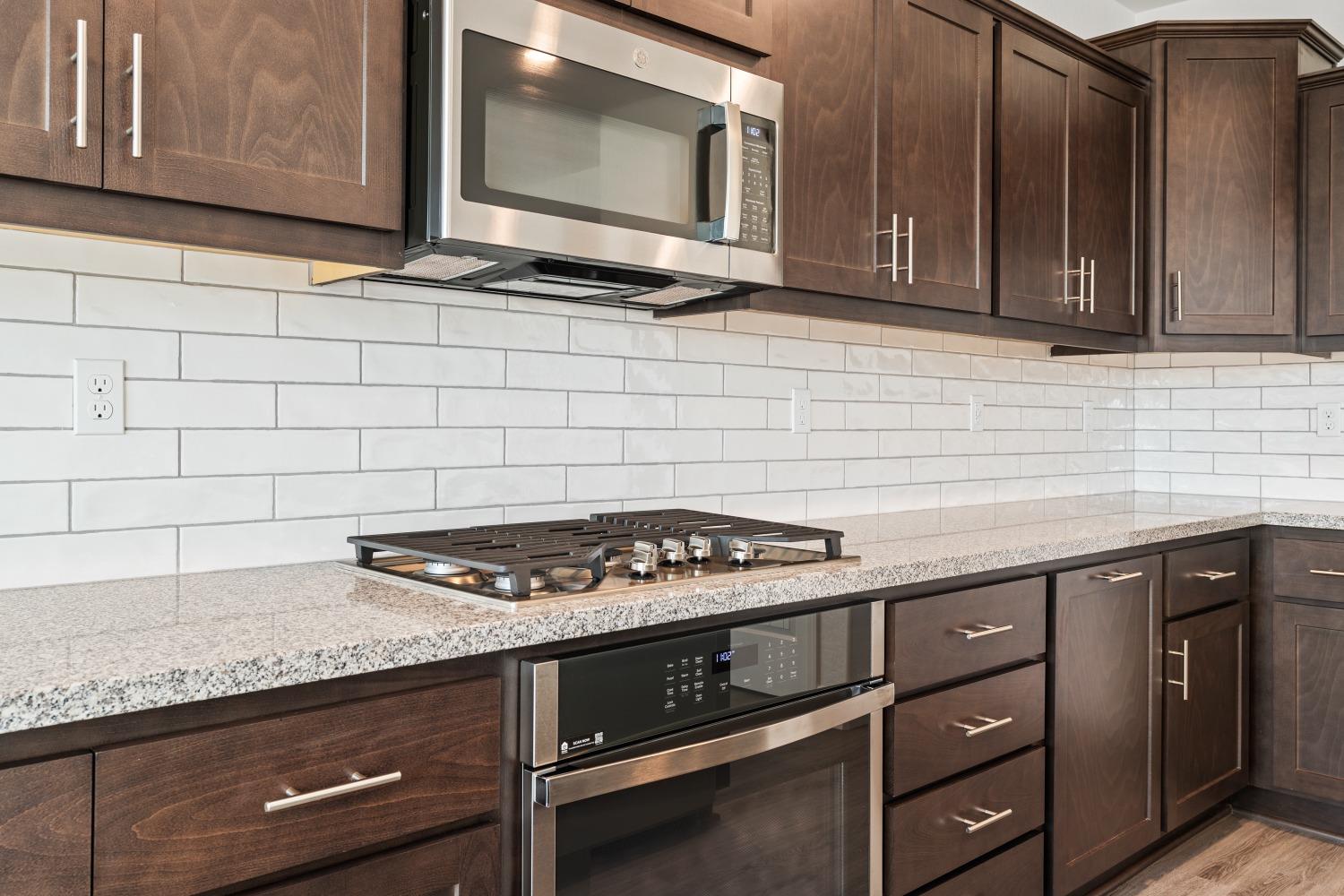 321 Peters Road Madera, CA 93636 - Photo 26 of 33 a kitchen with granite countertop cabinets stove top oven and microwave