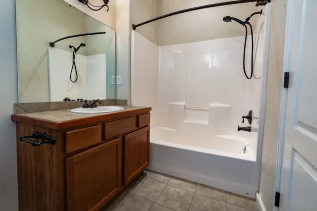 a bathroom with a bath tub sink vanity and mirror