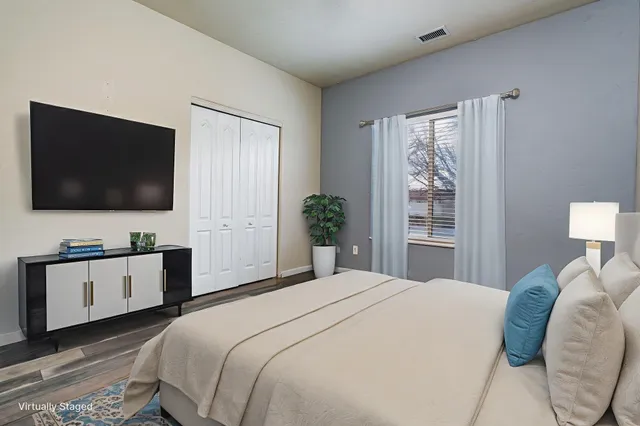 a bedroom with a large bed and a flat screen tv