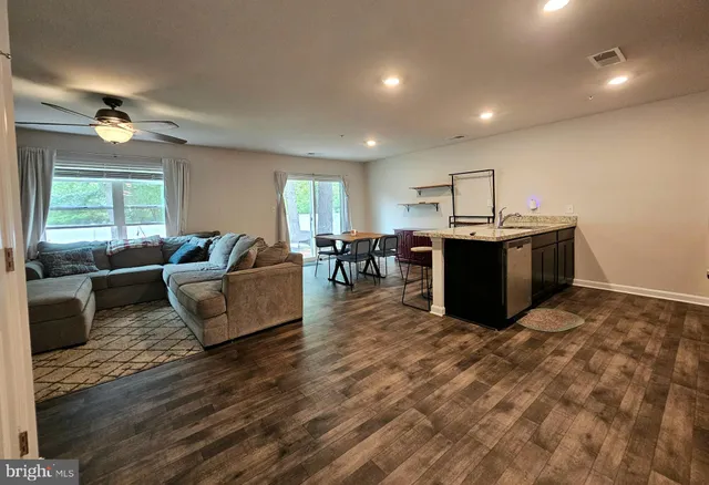 a living room with furniture a dining table and wooden floor