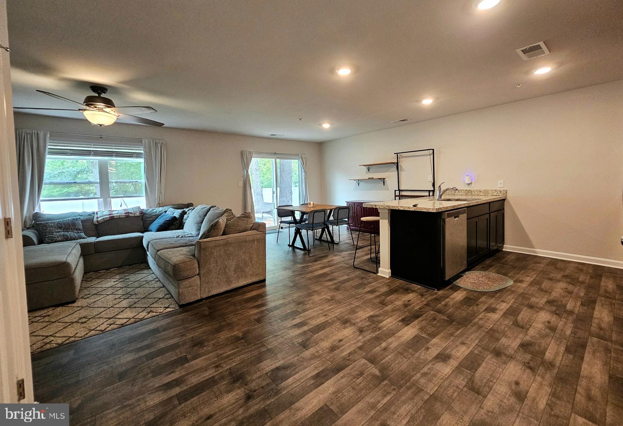 415 Creekside Trail Fruitland, MD 21826 - Photo 16 of 41 a living room with furniture a dining table and wooden floor