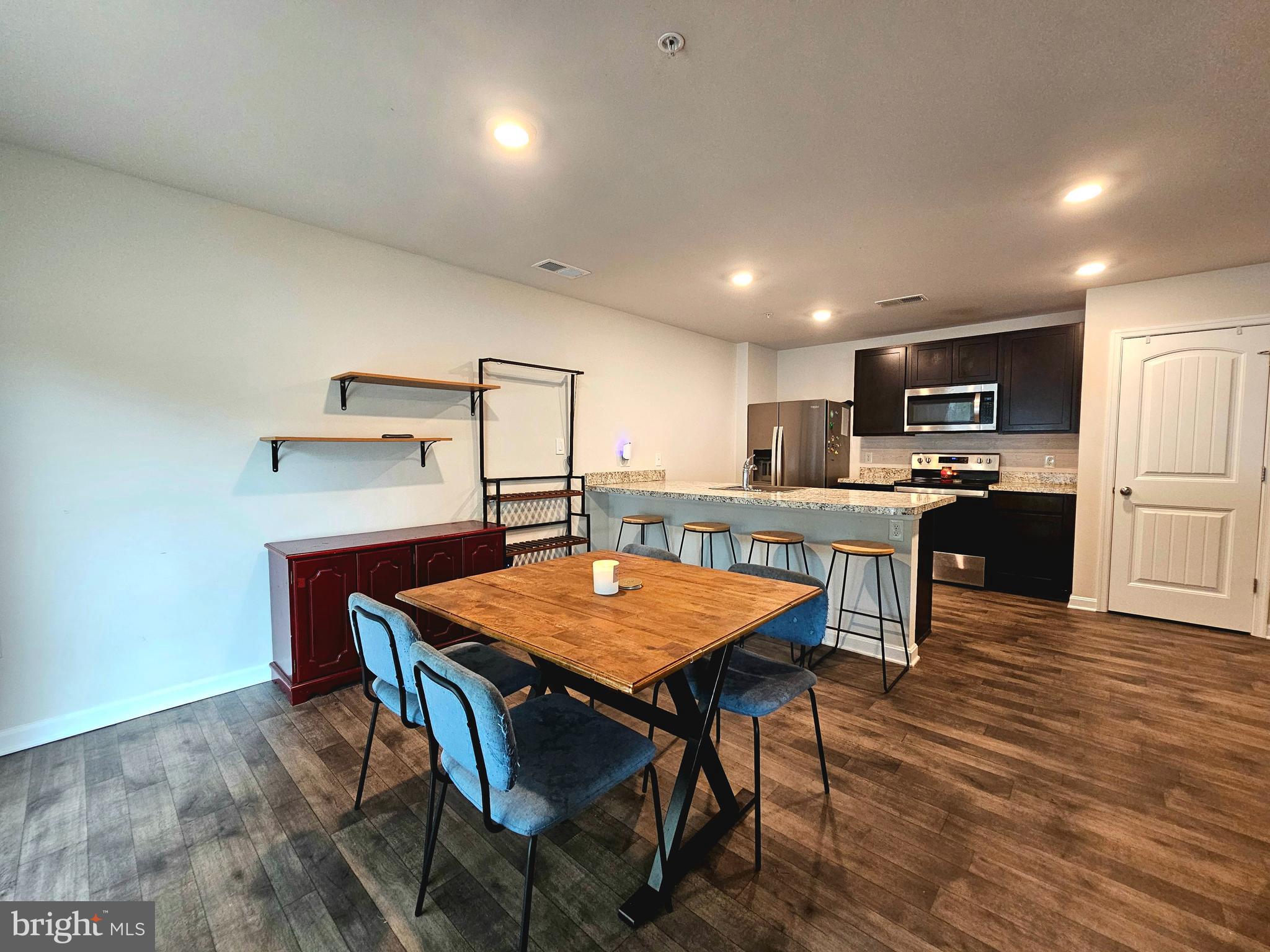 415 Creekside Trail Fruitland, MD 21826 - Photo 18 of 41 a kitchen with stainless steel appliances kitchen island granite countertop a dining table chairs and granite counter tops