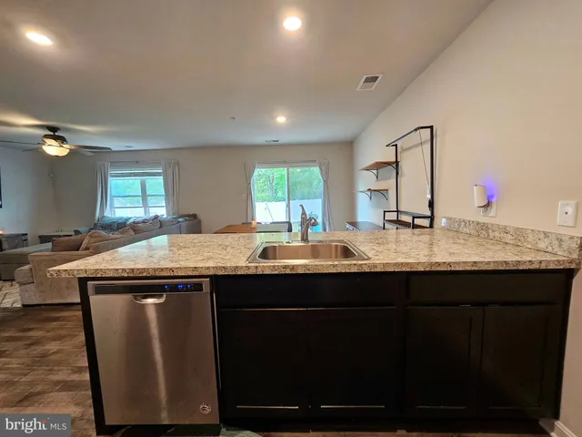 a kitchen with kitchen island a sink and wooden floor