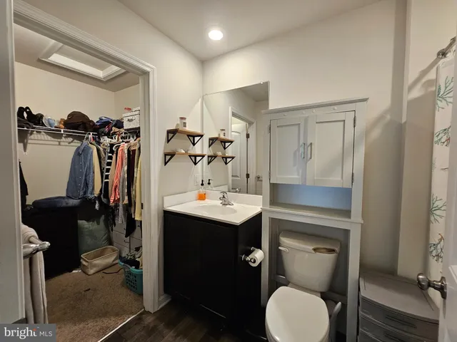 a bathroom with a sink vanity mirror and toilet