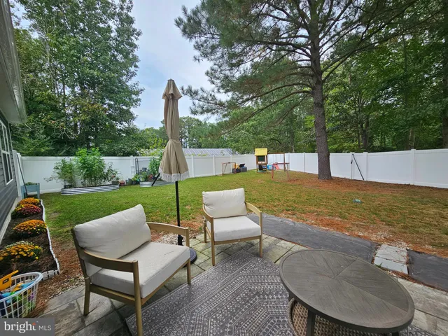 a view of a patio with furniture and a yard