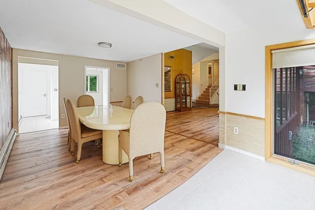 a dining room with wooden floor and furniture
