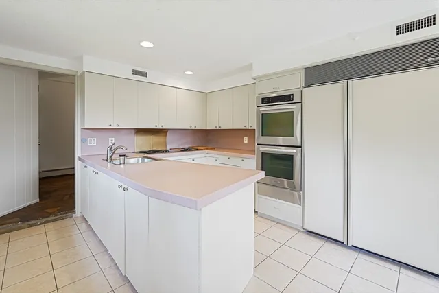 a large white kitchen with a stove top oven and cabinets