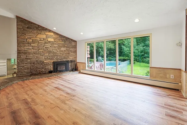 a view of empty room with wooden floor and fireplace