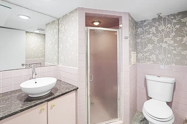 a bathroom with a granite countertop sink toilet and shower