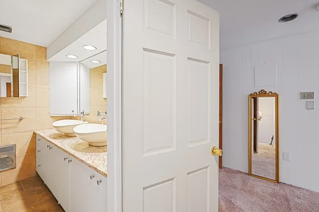 a bathroom with a granite countertop sink mirror and a bathtub