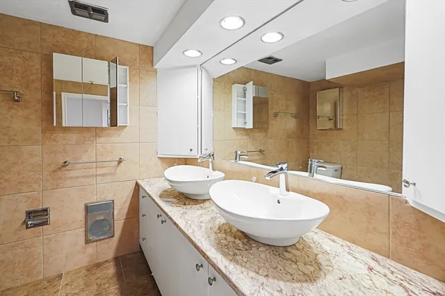 a bathroom with a granite countertop sink a toilet and mirror