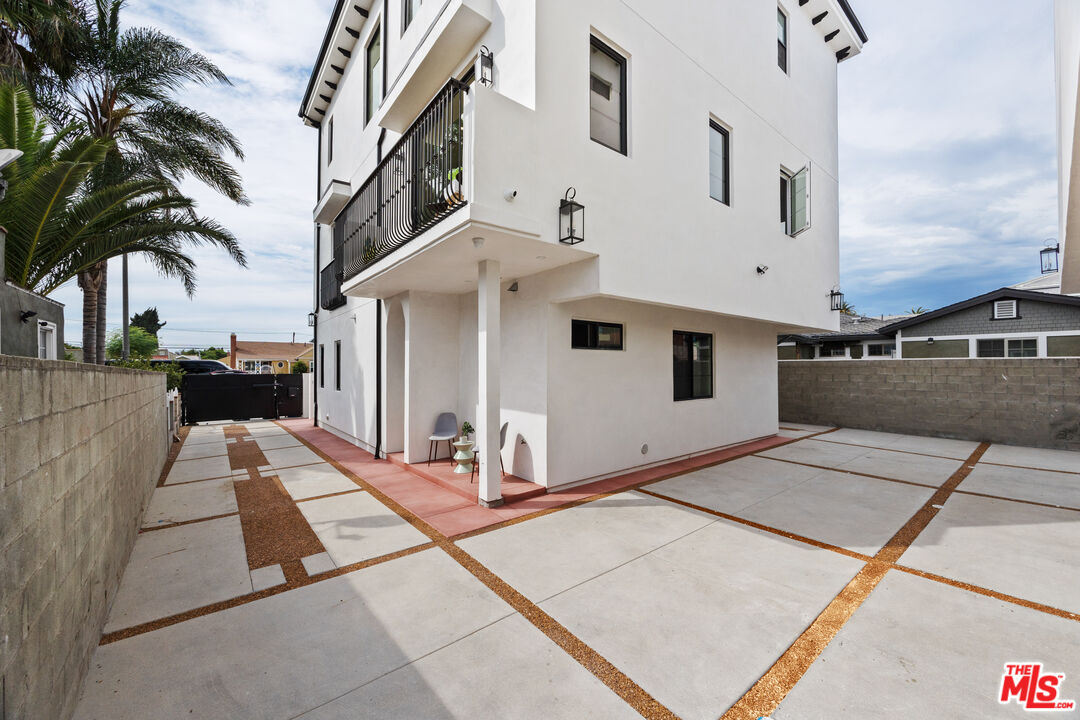 2324 South Dunsmuir Avenue, Unit 1/2 Los Angeles, CA 90016 - Photo 24 of 27 a view of a white house with a large tree