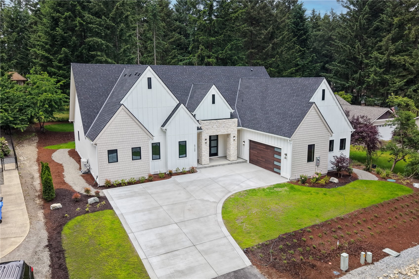 6709 254th Street East Graham, WA 98338 - Photo 2 of 40 a aerial view of a house next to a big yard and large trees