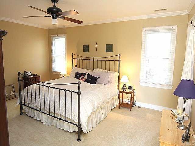 2716 Amstel Way Raleigh, NC 27613 - Photo 8 of 12 a bed sitting in a bedroom next to a window