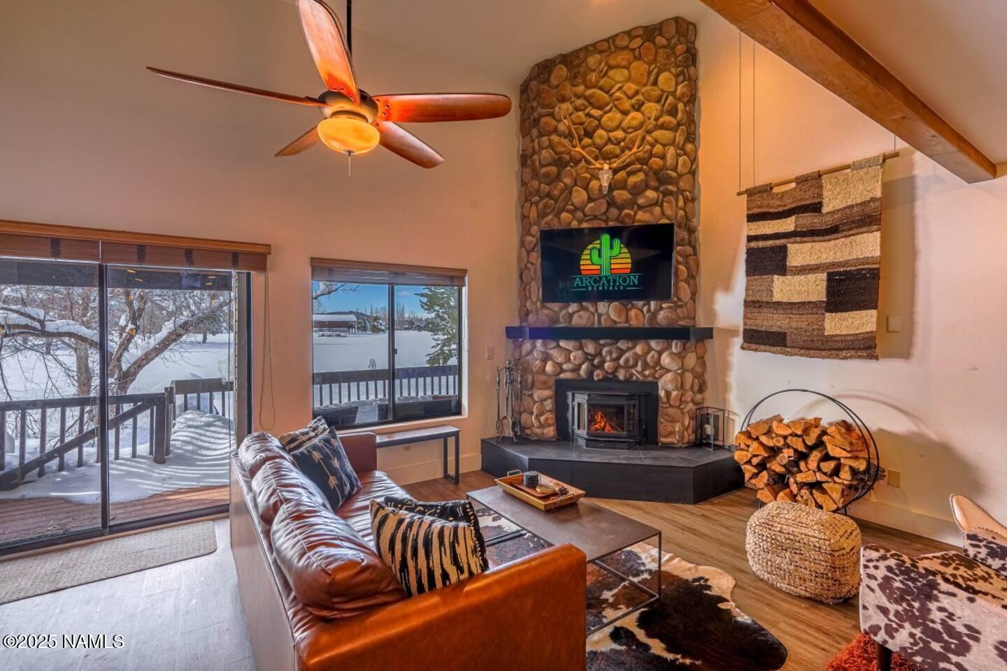 a living room with furniture a fireplace and a floor to ceiling window